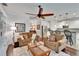 Inviting living room featuring dark hardwood floors, ceiling fan, and adjacent kitchen area at 2823 Holly Bluff Ct, Plant City, FL 33566