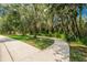 Concrete walking path amidst a serene, green landscaped area with mature trees at 2823 Holly Bluff Ct, Plant City, FL 33566
