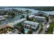 Aerial view of waterfront condo community featuring a pool, dock, and lush landscaping at 318 Windrush Blvd # 10, Indian Rocks Beach, FL 33785