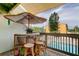 Balcony with tiki bar, stools, and an umbrella overlooking the community pool at 318 Windrush Blvd # 10, Indian Rocks Beach, FL 33785