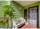 Inviting entryway with a charming bench, potted plant, and security door at 318 Windrush Blvd # 10, Indian Rocks Beach, FL 33785