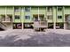 Exterior view of multi-story condo building with ground level parking and stairways at 318 Windrush Blvd # 10, Indian Rocks Beach, FL 33785