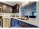 Modern kitchen with stainless steel appliances, quartz countertops, and a view to the living room at 318 Windrush Blvd # 10, Indian Rocks Beach, FL 33785