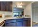 Renovated kitchen with sleek quartz countertops and stainless steel faucet overlooking the living room at 318 Windrush Blvd # 10, Indian Rocks Beach, FL 33785