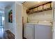 Bright laundry room with a full-sized washer, dryer, overhead storage and folding door access to maximize the space at 318 Windrush Blvd # 10, Indian Rocks Beach, FL 33785