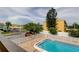 Community pool near a parking area with clear blue water and surrounding trees at 318 Windrush Blvd # 10, Indian Rocks Beach, FL 33785