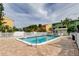 Sunny community pool with a white fence, loungers, and lush landscaping at 318 Windrush Blvd # 10, Indian Rocks Beach, FL 33785