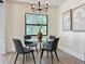 Bright dining area features modern chandelier, glass table, four chairs, and view to the exterior at 321 42Nd S Ave, St Petersburg, FL 33705