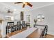 Open dining area showcasing a long wooden table, kitchen bar, and white cabinetry at 3220 W San Pedro St, Tampa, FL 33629