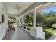 Inviting front porch with a ceiling fan, comfortable seating, and a view of the beautifully landscaped yard at 3220 W San Pedro St, Tampa, FL 33629