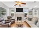 Bright living room featuring hardwood floors, a brick fireplace, comfortable seating, and ample natural light at 3220 W San Pedro St, Tampa, FL 33629