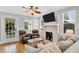 Cozy living room featuring hardwood floors, a brick fireplace, comfortable seating, and plenty of natural light at 3220 W San Pedro St, Tampa, FL 33629