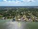 Aerial view showcases a waterfront property with lush landscaping and a private boat dock at 3290 Sunset N Dr, St Petersburg, FL 33710