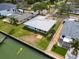 Waterfront property featuring a modern home with a metal roof, well-maintained lawn, and private access to the water at 3290 Sunset N Dr, St Petersburg, FL 33710