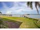 Backyard featuring well-maintained lawn, landscaping, and a waterfront view at 3290 Sunset N Dr, St Petersburg, FL 33710