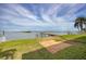 Tranquil waterfront backyard boasts a private pier, grass and a bricked area at 3290 Sunset N Dr, St Petersburg, FL 33710