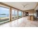 Bright sunroom with large windows and views of the water, ready for renovation with tile floors and ample natural light at 3290 Sunset N Dr, St Petersburg, FL 33710