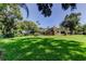 Large backyard features lush lawn, mature trees and a screened in patio at 3353 Wedgewood Way, Tarpon Springs, FL 34688