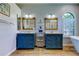 Bathroom featuring dual vanities with wood framed mirrors and a storage shelf between the vanities at 3353 Wedgewood Way, Tarpon Springs, FL 34688