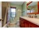 Elegant bathroom featuring a wood vanity, stone countertop and warm light at 3353 Wedgewood Way, Tarpon Springs, FL 34688