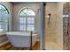 Freestanding tub with floor mounted faucet and a shower featuring decorative tile and a glass door at 3353 Wedgewood Way, Tarpon Springs, FL 34688
