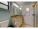 Bathroom featuring a vanity with tan countertop, a mirror and a shower with glass doors at 3353 Wedgewood Way, Tarpon Springs, FL 34688