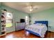 Bright bedroom with hardwood floors, soft blue walls, and windows overlooking the lawn at 3353 Wedgewood Way, Tarpon Springs, FL 34688