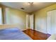 This bedroom features wood floors, a closet, and a neutral color palette at 3353 Wedgewood Way, Tarpon Springs, FL 34688