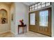 Inviting foyer with a decorative table, tiled flooring, and a stylish front door with glass panels at 3353 Wedgewood Way, Tarpon Springs, FL 34688
