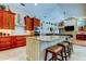 Open-concept kitchen with an island, granite countertops, custom cabinets and adjacent living area at 3353 Wedgewood Way, Tarpon Springs, FL 34688