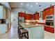 Well-appointed kitchen featuring custom cabinets, an island with seating, and stainless steel appliances at 3353 Wedgewood Way, Tarpon Springs, FL 34688