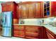 Custom kitchen with granite countertops, ample cabinet space, and stainless steel refrigerator at 3353 Wedgewood Way, Tarpon Springs, FL 34688