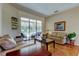Bright living room featuring hardwood floors, neutral sofas, and sliding glass doors to the screened-in patio at 3353 Wedgewood Way, Tarpon Springs, FL 34688