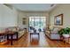 Bright living room featuring hardwood floors, neutral sofas, and sliding glass doors to the screened-in patio at 3353 Wedgewood Way, Tarpon Springs, FL 34688