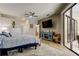Main bedroom with ceiling fan, dresser, TV, slider door with view of outdoor living space at 3353 Wedgewood Way, Tarpon Springs, FL 34688