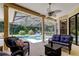 Covered patio features comfortable seating with views of the private screened-in pool at 3353 Wedgewood Way, Tarpon Springs, FL 34688
