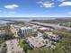 Aerial view of condos with mature trees, highway, and water views beyond at 345 S Mcmullen Booth Rd # 142, Clearwater, FL 33759