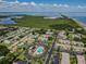 This aerial view showcases the community pool, nearby homes, and a stunning waterfront vista beyond lush greenery at 345 S Mcmullen Booth Rd # 142, Clearwater, FL 33759