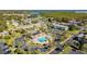 Overhead view showcases community pool area surrounded by palm trees, building, and parking at 345 S Mcmullen Booth Rd # 142, Clearwater, FL 33759