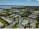 Aerial view showing condominium complex with pool, parking, and lush landscaping near the water at 345 S Mcmullen Booth Rd # 142, Clearwater, FL 33759