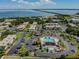 Aerial view of condominium community with pool, parking, and surrounding landscape near the water at 345 S Mcmullen Booth Rd # 142, Clearwater, FL 33759