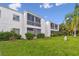Exterior view of a two-story condominium building with well-maintained landscaping and green lawns at 345 S Mcmullen Booth Rd # 142, Clearwater, FL 33759