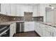 Modern kitchen with white cabinetry, stainless steel appliances, and decorative backsplash at 345 S Mcmullen Booth Rd # 142, Clearwater, FL 33759
