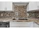 A close-up of a kitchen sink features a stainless steel faucet and decorative backsplash at 345 S Mcmullen Booth Rd # 142, Clearwater, FL 33759