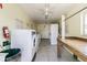 Bright laundry room with multiple washers and dryers, a folding table, and tiled floors at 345 S Mcmullen Booth Rd # 142, Clearwater, FL 33759