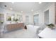 Bright bathroom featuring double vanity, modern soaking tub, and marble tile at 35 Deerpath Dr, Oldsmar, FL 34677