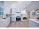 Modern kitchen featuring marble countertops, stainless steel appliances, and sleek white cabinetry at 35 Deerpath Dr, Oldsmar, FL 34677