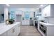 Bright kitchen featuring white cabinets, stainless steel appliances, and stunning marble countertops at 35 Deerpath Dr, Oldsmar, FL 34677