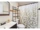 Bright bathroom featuring a shower with leaf-patterned curtain, dark wood cabinets, and modern fixtures at 4014 Dream Oak Pl # 202, Tampa, FL 33613