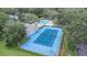 Overhead view of a community blue tennis court next to a swimming pool and lots of green trees at 4014 Dream Oak Pl # 202, Tampa, FL 33613
